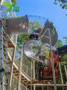 European pinecone outdoor playground with natural wooden cabins, rope bridges, and climbing structures