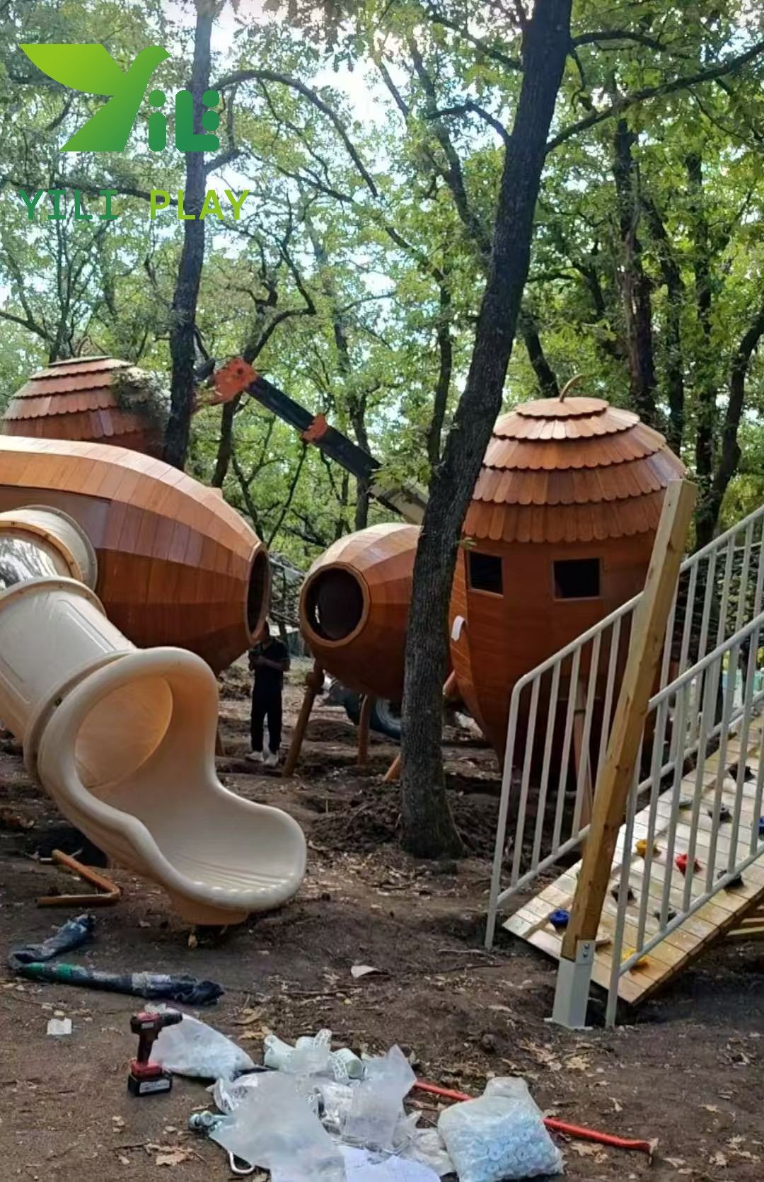 European pinecone outdoor playground with natural wooden cabins, rope bridges, and climbing structures