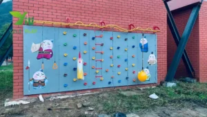 Climbing wall for kids with colorful holds, rope ladders, and cartoon decorations in an outdoor playground